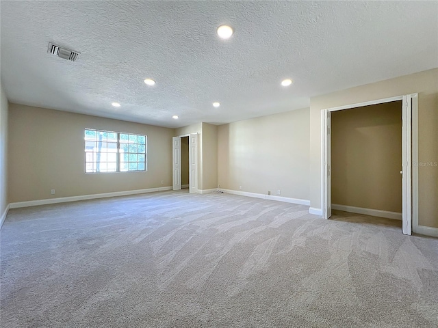 interior space featuring light colored carpet and a textured ceiling