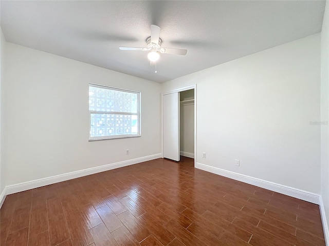 unfurnished bedroom featuring ceiling fan, dark hardwood / wood-style floors, a textured ceiling, and a closet