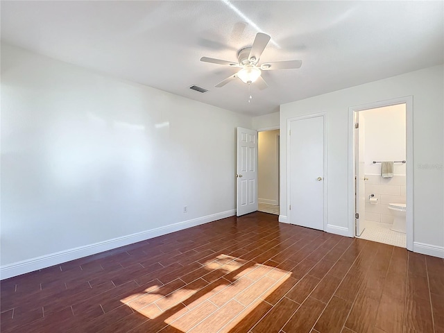 unfurnished bedroom featuring dark hardwood / wood-style floors, ceiling fan, and ensuite bath