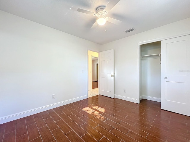 unfurnished bedroom featuring a closet, dark hardwood / wood-style floors, and ceiling fan