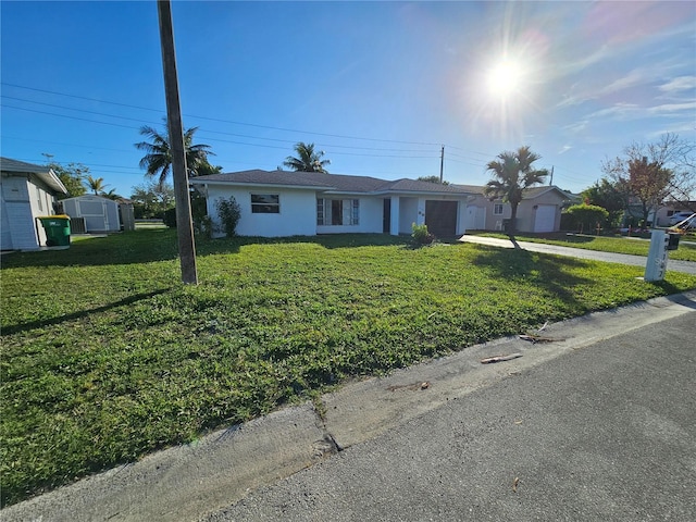 ranch-style home with a storage shed and a front lawn