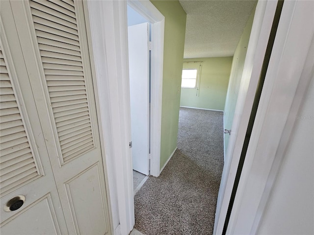 corridor featuring carpet floors and a textured ceiling