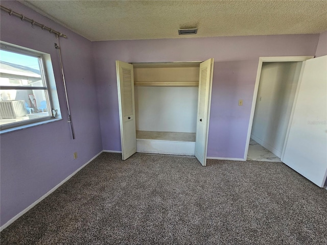 unfurnished bedroom featuring a closet, carpet, and a textured ceiling