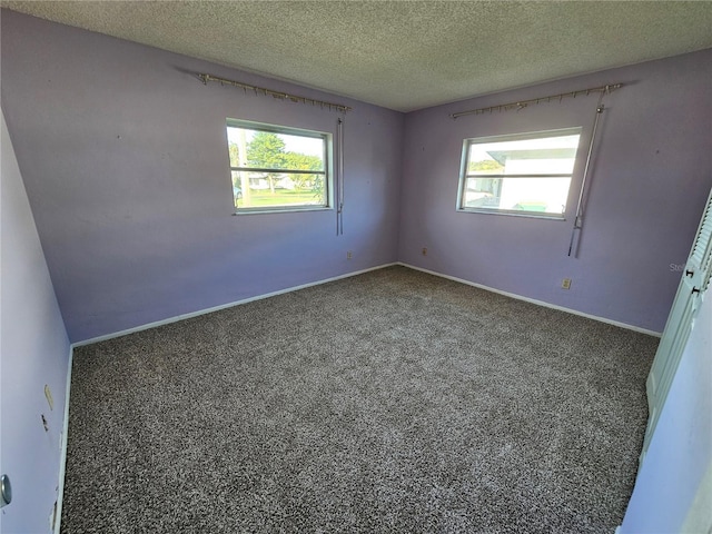 spare room featuring a textured ceiling and a healthy amount of sunlight