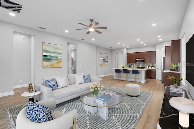 living room with light wood-type flooring and ceiling fan