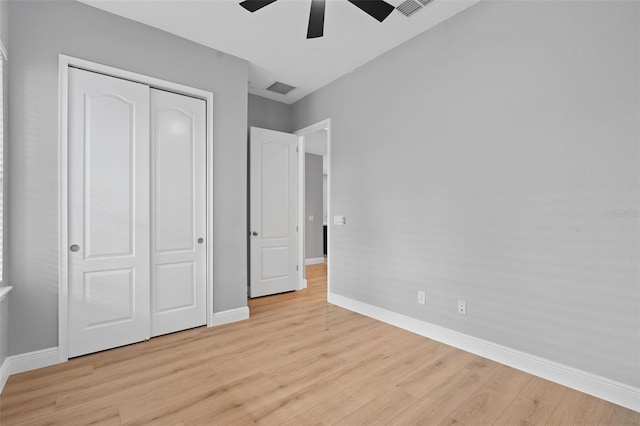 unfurnished bedroom featuring a closet, light hardwood / wood-style floors, and ceiling fan