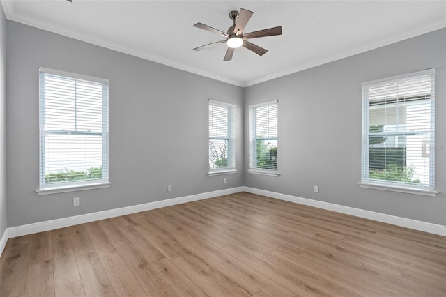 unfurnished room featuring crown molding, plenty of natural light, and light wood-type flooring