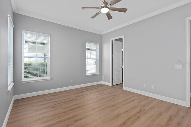 empty room with crown molding, plenty of natural light, and light hardwood / wood-style floors