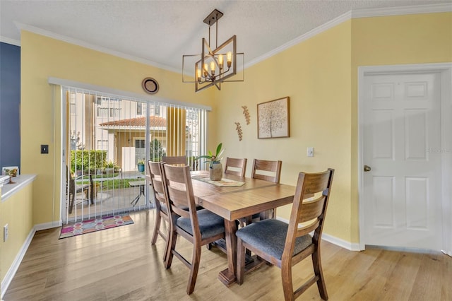 dining room featuring crown molding, light hardwood / wood-style flooring, a textured ceiling, and an inviting chandelier