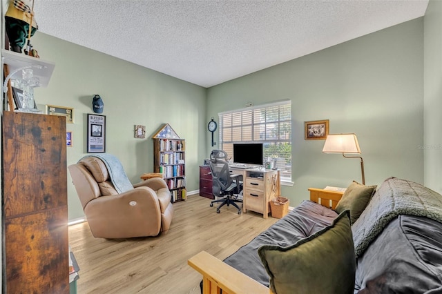 living room featuring light wood-type flooring and a textured ceiling