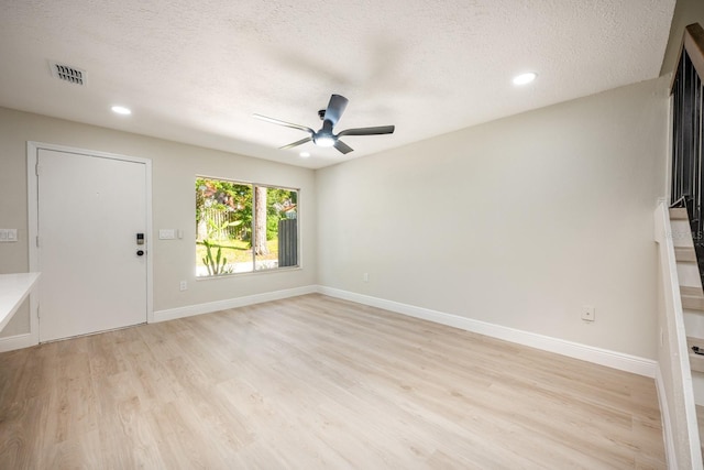 interior space featuring ceiling fan, light hardwood / wood-style floors, and a textured ceiling