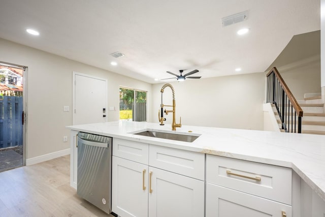 kitchen with white cabinetry, ceiling fan, sink, stainless steel dishwasher, and light hardwood / wood-style floors