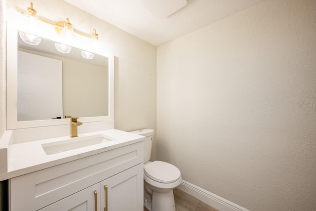 bathroom with hardwood / wood-style flooring, vanity, and toilet