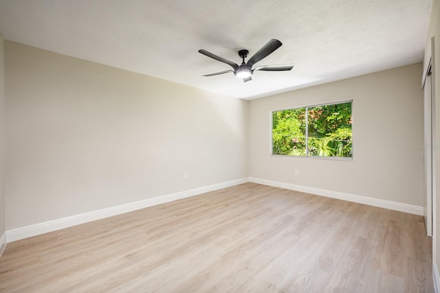 spare room with ceiling fan, light hardwood / wood-style floors, and a textured ceiling