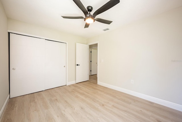 unfurnished bedroom with ceiling fan, light hardwood / wood-style floors, and a closet