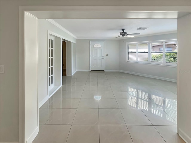 interior space featuring ceiling fan, light tile patterned flooring, and ornamental molding