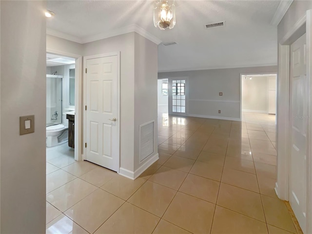 hall featuring light tile patterned flooring and crown molding