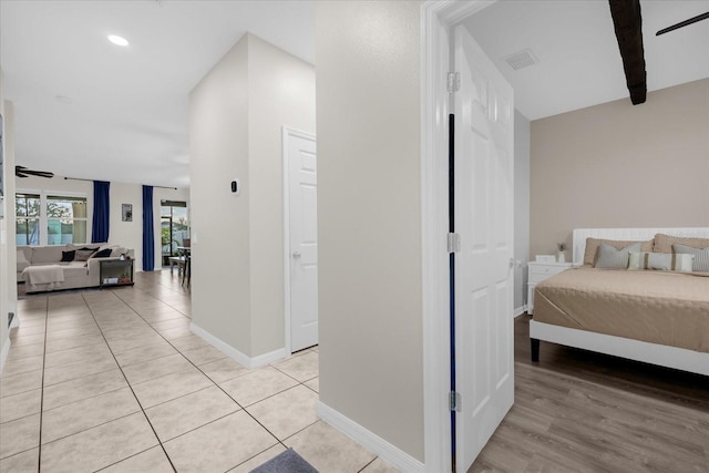 hallway with beam ceiling and light tile patterned flooring