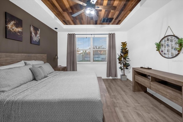 bedroom with a tray ceiling, wood ceiling, hardwood / wood-style flooring, and ceiling fan