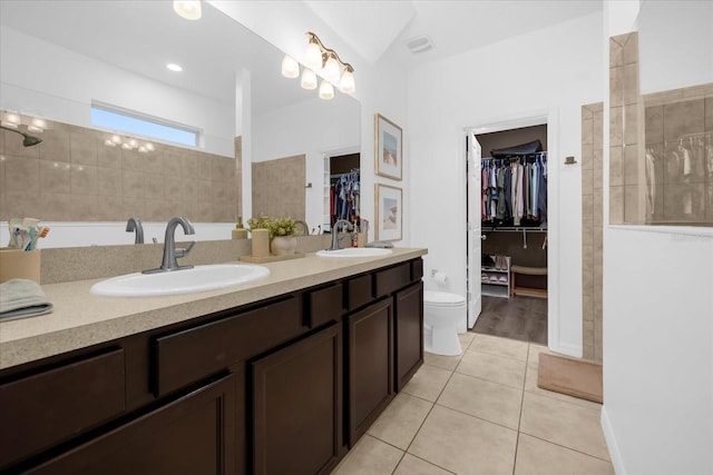 bathroom with tile patterned flooring, vanity, toilet, and lofted ceiling