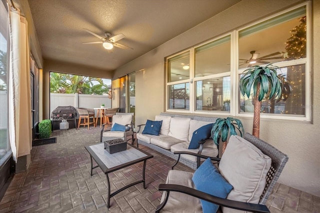 sunroom featuring ceiling fan