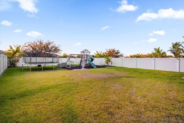 view of yard with a playground and a trampoline