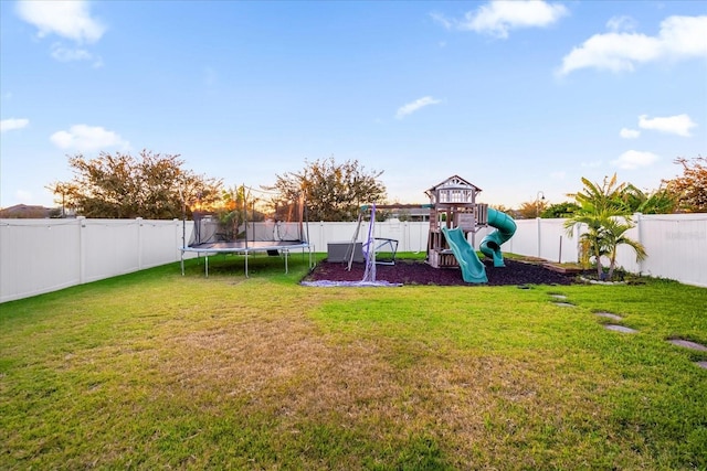 view of playground featuring a trampoline and a lawn