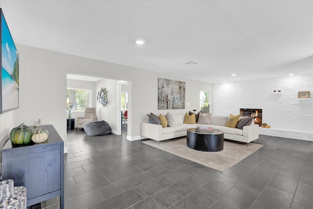 tiled living room with a stone fireplace and plenty of natural light