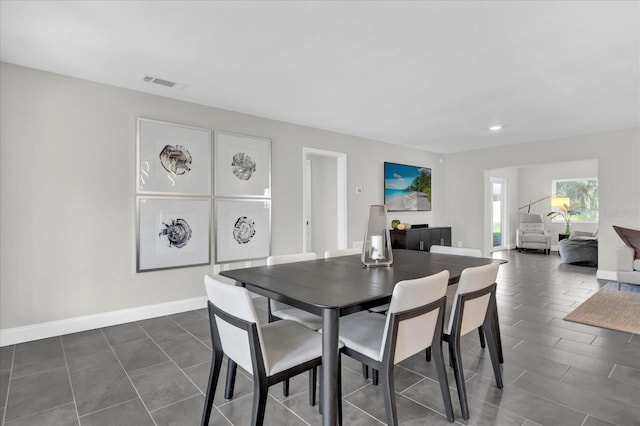 dining space featuring dark tile patterned floors