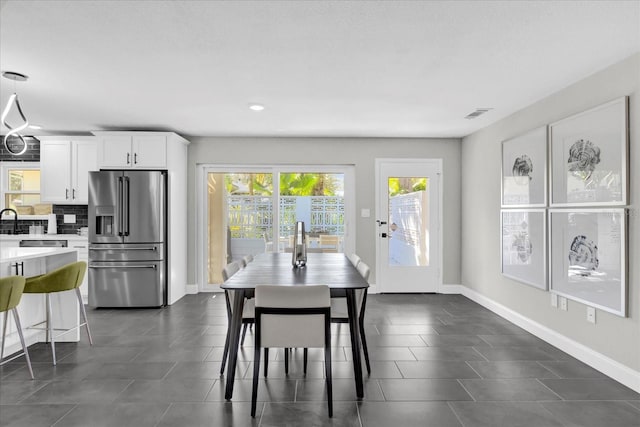 dining area featuring dark tile patterned floors