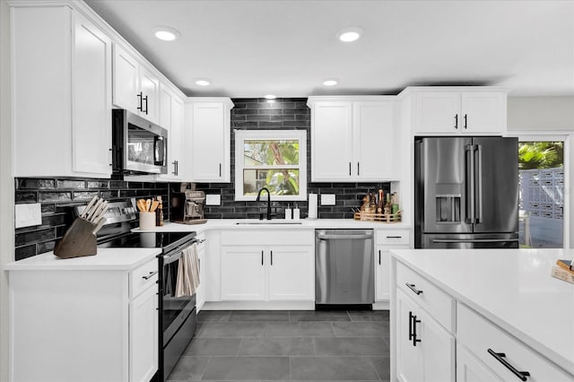 kitchen featuring stainless steel appliances, white cabinetry, and sink