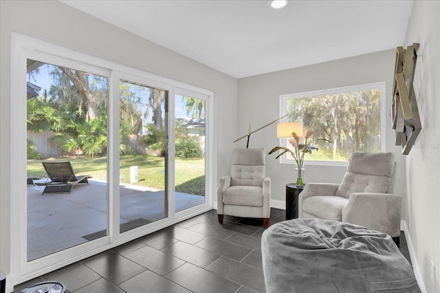 sitting room with dark tile patterned flooring and plenty of natural light