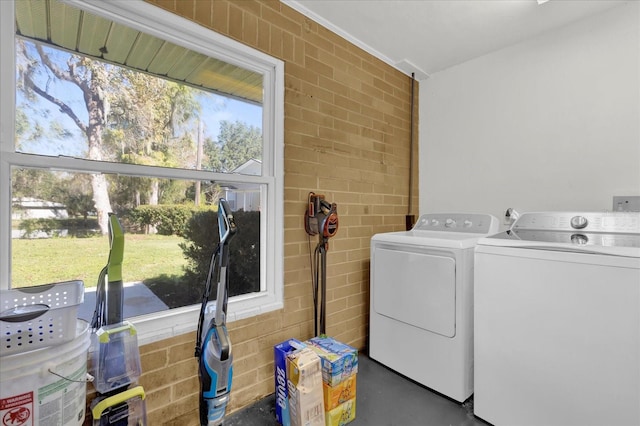 washroom featuring washer and dryer and brick wall