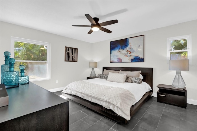 tiled bedroom featuring multiple windows and ceiling fan