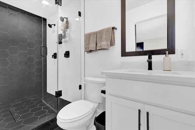 bathroom with vanity, toilet, and a shower with door