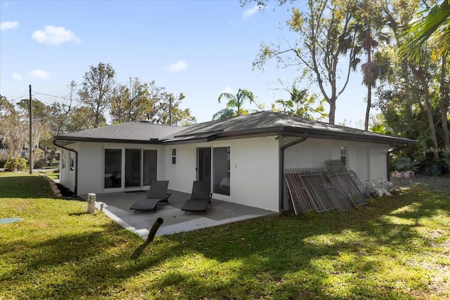 back of house with a yard and a patio