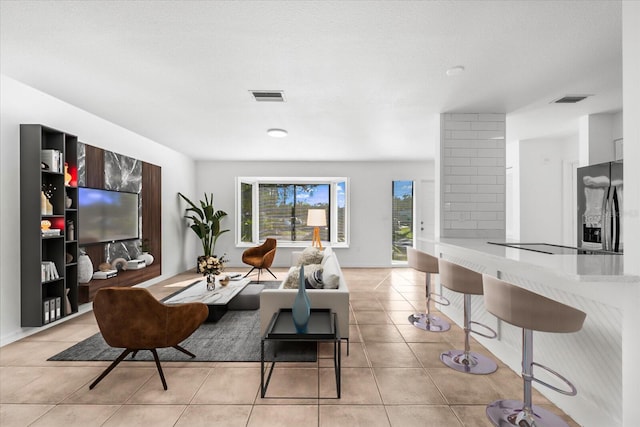 living room featuring a textured ceiling and light tile patterned flooring