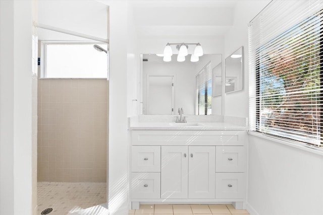 bathroom featuring vanity, a tile shower, and tile patterned flooring