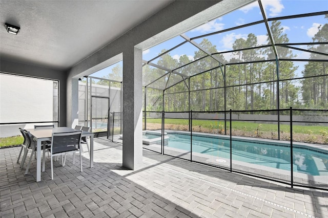 view of pool with glass enclosure and a patio area