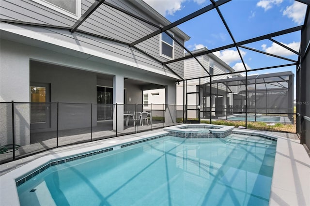 view of pool featuring an in ground hot tub, a patio, and glass enclosure