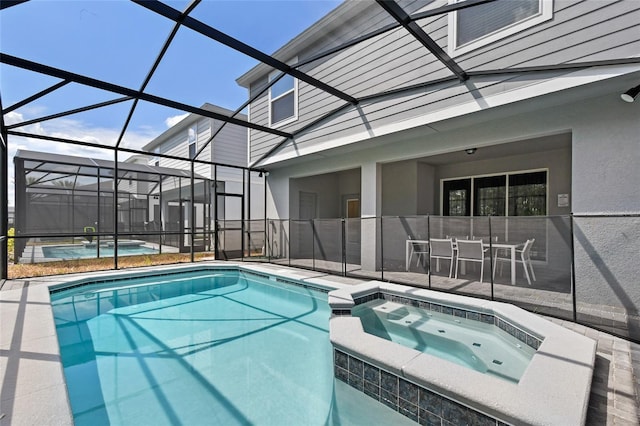 view of pool featuring glass enclosure, a patio area, and an in ground hot tub