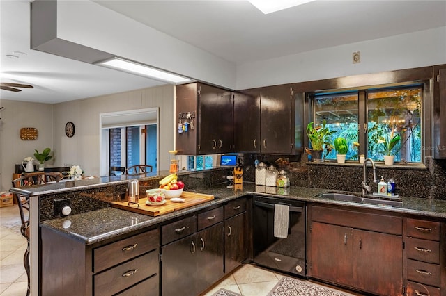 kitchen featuring sink, dark stone countertops, dark brown cabinetry, black dishwasher, and kitchen peninsula