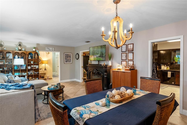 dining room with a notable chandelier, light tile patterned floors, and a fireplace