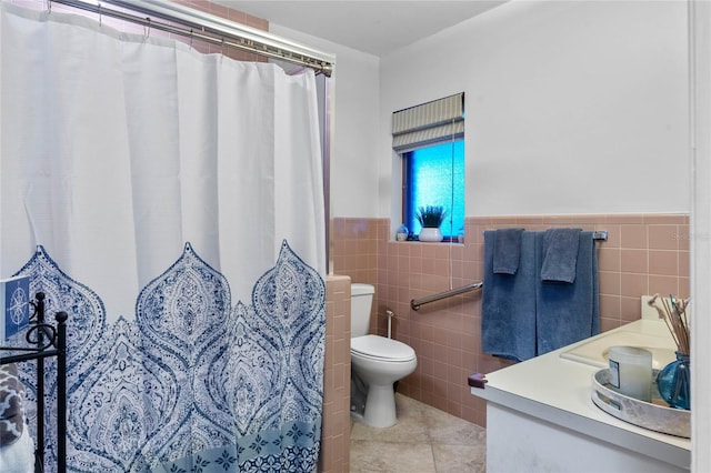 bathroom with walk in shower, tile patterned floors, toilet, vanity, and tile walls