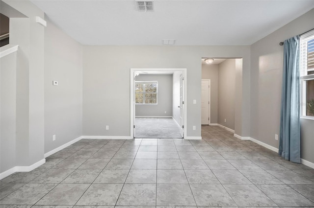 tiled empty room featuring a wealth of natural light