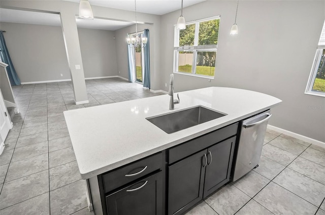 kitchen with a center island with sink, sink, light tile patterned flooring, pendant lighting, and dishwasher