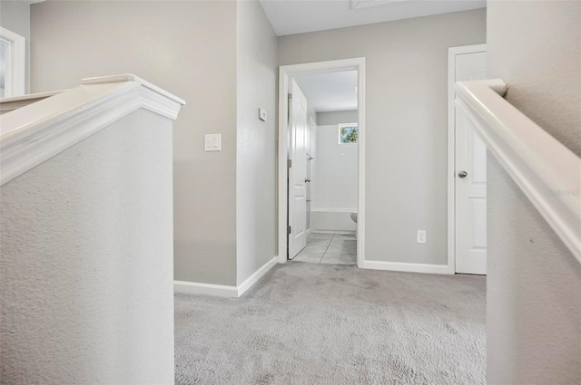 hall with light colored carpet