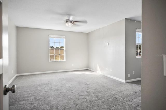 carpeted empty room with a wealth of natural light and ceiling fan