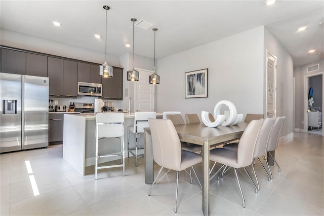 tiled dining room featuring sink