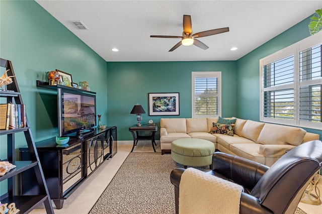 living room featuring a textured ceiling and ceiling fan